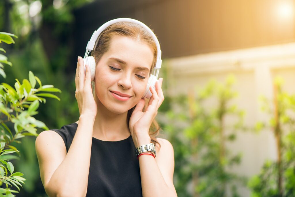 Person listening to headphones and smiling
